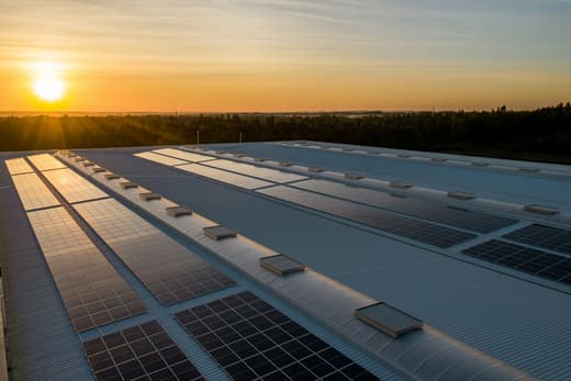 Grande toiture équipée de panneaux solaires au coucher du soleil