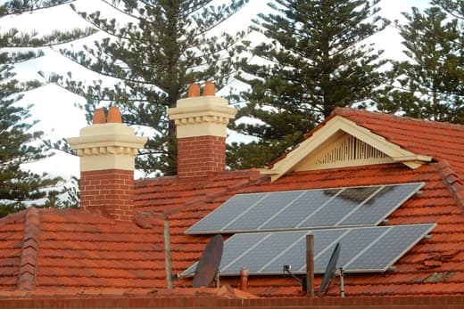 Panneaux solaires posés sur une toiture ancienne en tuiles